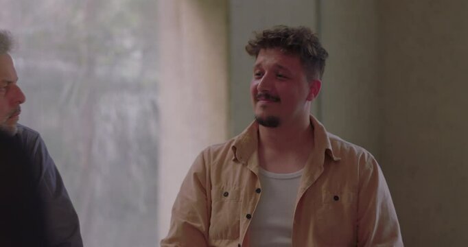 Man sharing emotionally in group therapy, using expressive gestures to communicate truth and connect with others in supportive environment