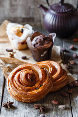 Sweet cinnamon buns roll swirl with spices and cocoa on parchment paper. Sweet Homemade pastry christmas baking. Sweets and dessert, close up