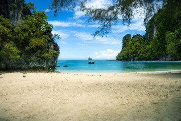 Stunning tropical beach in Krabi Province, Thailand, with white sand, turquoise waters, and dramatic limestone cliffs. Ideal for tropical beach pictures, beach screensavers