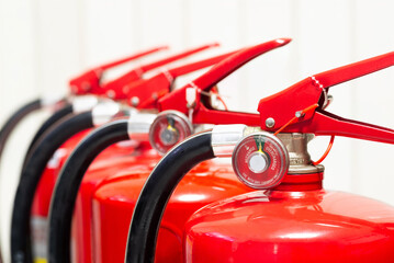 Closeup view of multiple fire extinguishers lined up for safety and emergency used