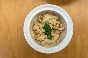 Stir fried chicken with garlic served on white bowl.
