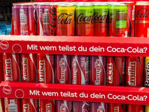 Colorful coca-cola display with personalized names and flavors in german text