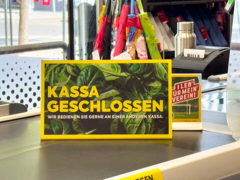 Kassa closed sign on checkout counter with spinach background in german store