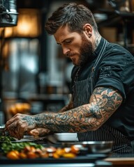 Focused tattooed chef preparing food in a professional kitchen with intense concentration