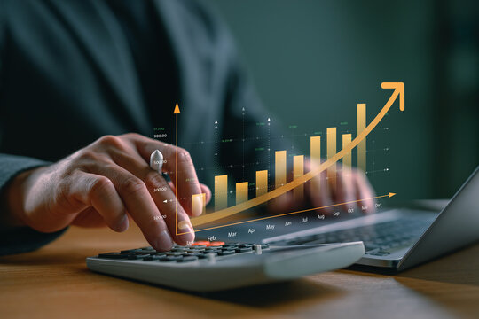 Financial growth and accounting analysis concept with businessman using calculator and virtual bar chart. Perfect for business success, revenue growth, finance report, and investment planning.