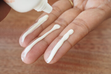 Applying sunscreen cream to fingers for skincare routine