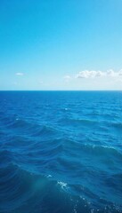 Fototapeta premium Vast expanse of deep blue ocean water, waves gently rolling under a clear sky Perfect for travel, nature, or environmental themes , water, coastline