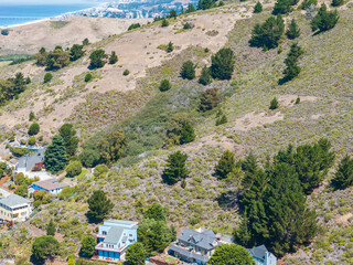 Aerial view of residential neighborhoods, coastal roads, and the Pacific Ocean from the hillside...