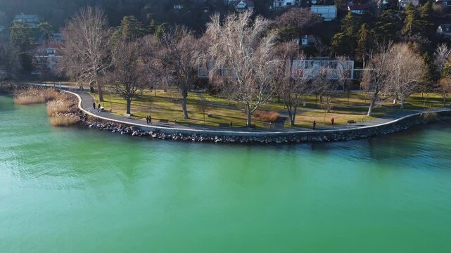 Kis Mohle pier along vivid green lake waters surrounded by trees and residential shoreline