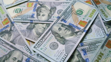 A large pile of currency featuring hundred dollar bills showcasing financial wealth and assets