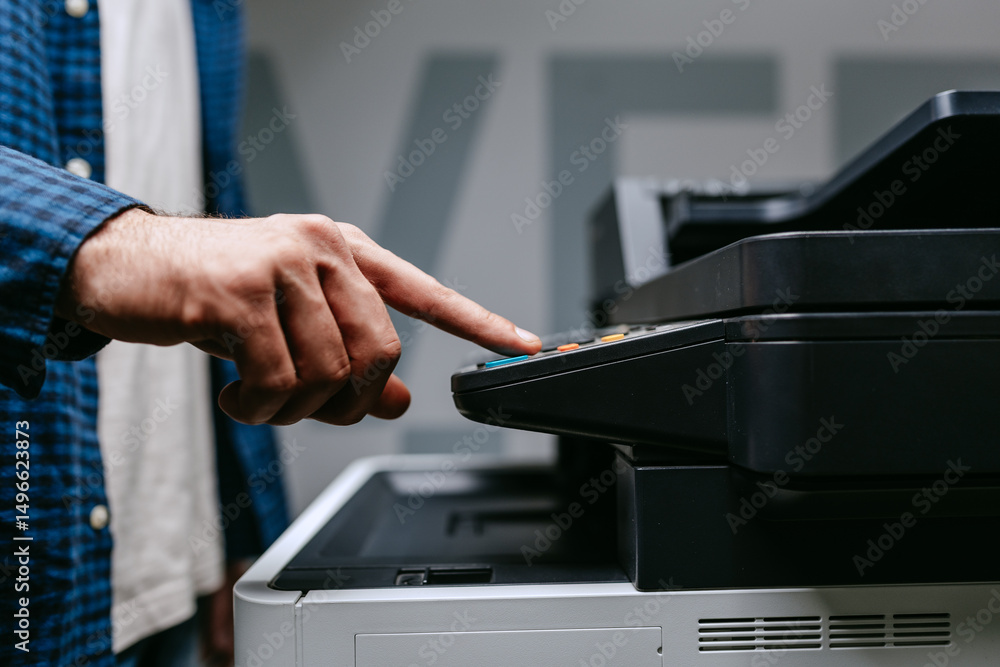 Poster person operating a copier in an office setting during daylight hours while preparing to make copies 