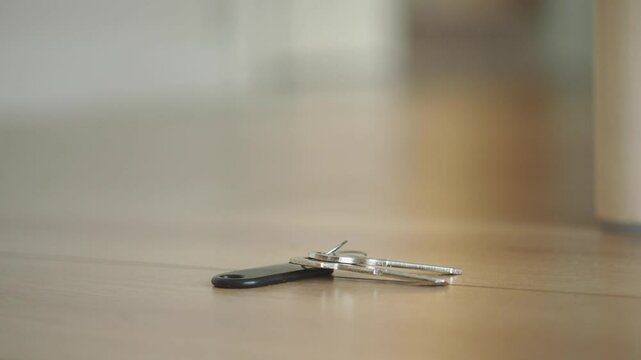 Keys on the floor near a wooden table, lost key concept 
