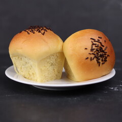 bluder cake with chocolate sprinkles topping and filled with chocolate paste. in the photo with a black marble background