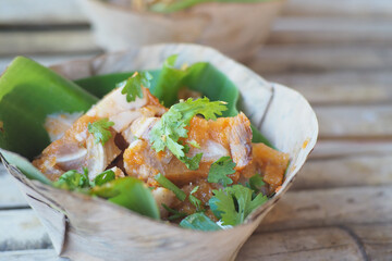 Deliciously presented dish featuring tender meat and fresh herbs in eco-friendly packaging.