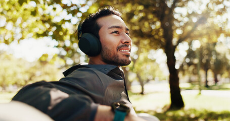 Thinking, man and headphones for fitness in city by listening to music, streaming audio and break. Male person, thoughts and relax with exercise podcast, workout recovery and ideas of sports training