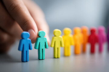 Hand choosing LGBT figurine symbolizing identity search, personal acceptance, social inclusion, and gender expression