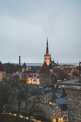 Scenic view of Tallinn's Old Town with historic architecture and a church spire under a cloudy sky