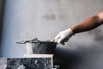 Construction worker applying cement mixture workshop industry indoor close-up craftsmanship and precision