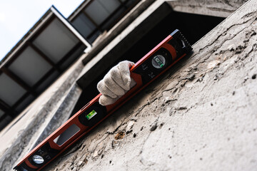 Construction worker leveling wall in urban setting detailed inspection close-up view construction...