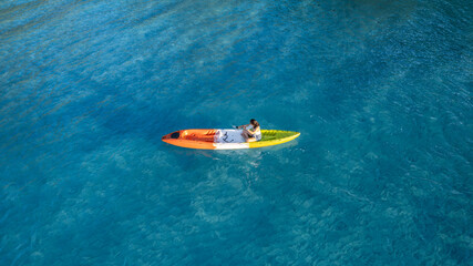 Aerial view of a kayak in the blue sea .man kayaking he does water sports activities.	