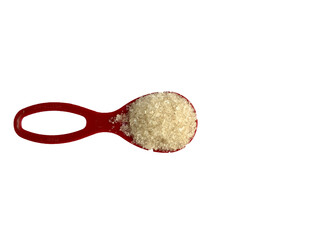Close up a spoonful sugar isolated on white background. Sugar on a red spoon with copy space