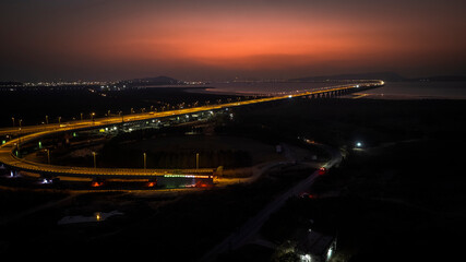 India's longest sea bridge: Trans-Harbour Sea Link. Atal Setu sea bridge in Mumbai, Maharashtra, India. Time-lapse of a city at night with bright skyscrapers and a dense network of glowing buildings.