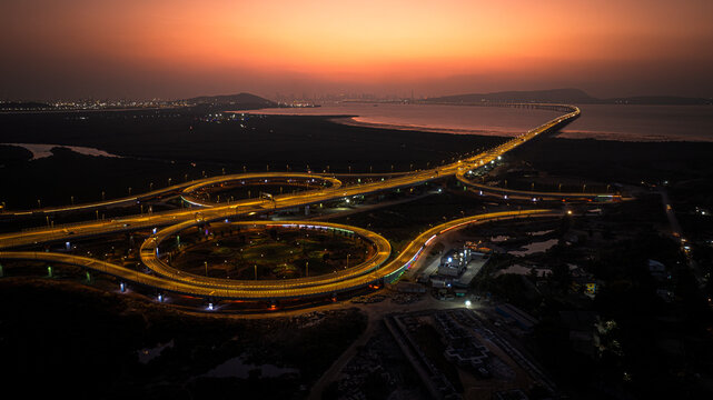 India's longest sea bridge: Trans-Harbour Sea Link. Atal Setu sea bridge in Mumbai, Maharashtra, India. Time-lapse of a city at night with bright skyscrapers and a dense network of glowing buildings.