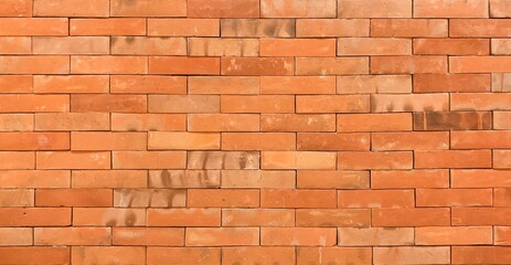Close-up of red brick wall texture in natural light. Ideal for backgrounds, construction themes, or architectural design concepts. 