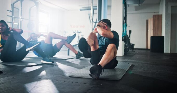 Workout, class and people do sit up in gym for core exercise, fitness and training for challenge. Health club, sports and men with women and personal trainer for strength, wellness or strong muscles