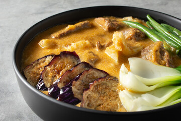 A closeup view of a bowl of kare-kare.