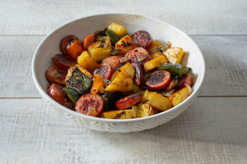 A view of a bowl of kielbasa and pineapple.