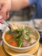 Authentic Northern Thai young jackfruit curry (Gaeng Khanun or Gaeng Ba Nun), a flavorful and aromatic herbal soup with tender jackfruit, pork ribs, and various local vegetables and herbs, being serve