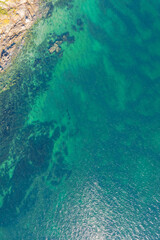 aerial top down drone view, coastal feature in a rocky shore with turquoise water