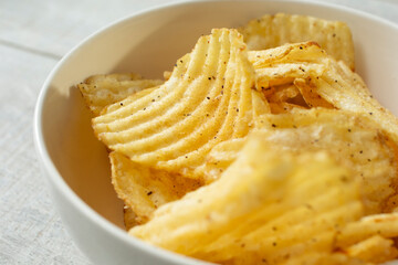 A closeup view of a bowl of ridged potato chips.