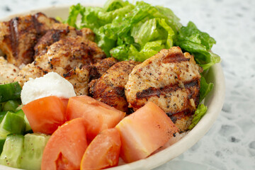 A closeup view of a chicken kebab salad bowl.