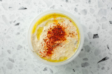 A top down view of a container of baba ganouj.