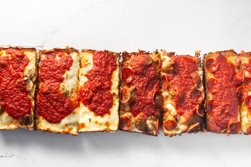 A top down view of slices of Detroit style pizza.