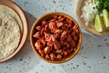 A top down view of a bowl of al pastor meat.