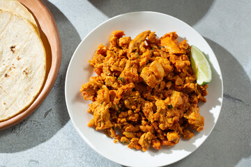 A top down view of a pile of pollo asado meat on a plate.