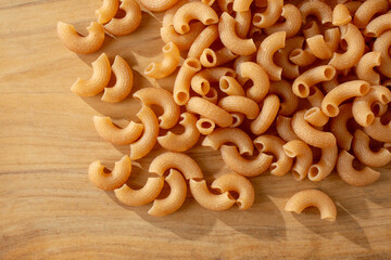 A top down view of a pile of dry cassava elbow pasta.