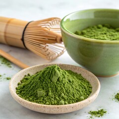Matcha green tea powder in bowl and whisk on white background.