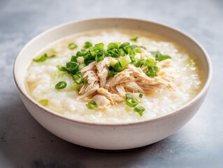 Bowl of chicken congee with shredded chicken and green onions, comforting Asian dish