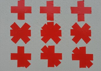 Obraz premium Red plus signs and star shapes arranged on a textured off white surface