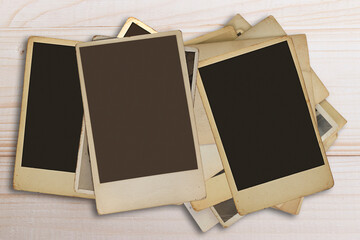 collection of old and Polaroid photo frames. on a wooden floor.