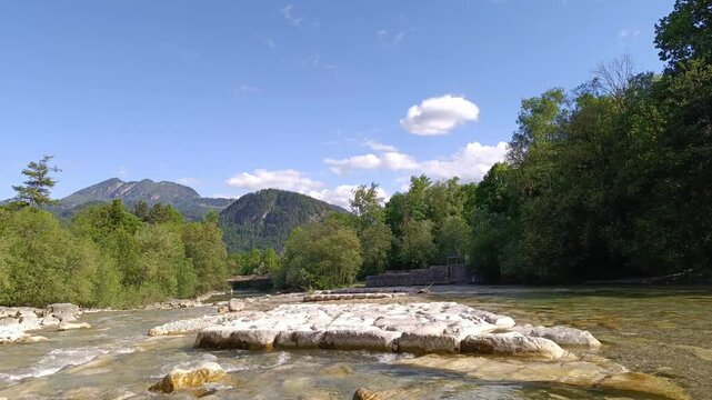 Relaxing riverside view with mountains in the background during a sunny afternoon in a natural setting close to the water