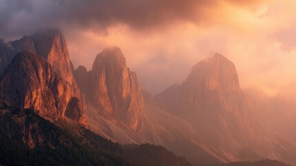 Naklejka premium mountain peaks with orange sunset light and fog a summer travel vacation, landscape photography.