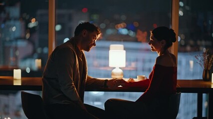 Flirting couple sitting dark restaurant in lamp light closeup. Smiling spouses