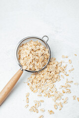 Oats being sifted in a strainer on a light-colored surface