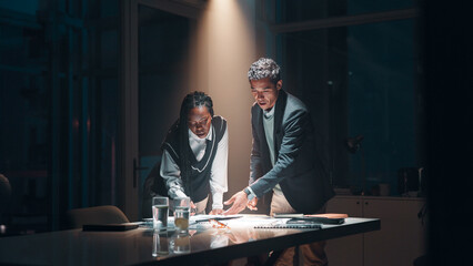 Management, documents and business people at night meeting for overtime, planning or research. Creative startup, collaboration and man with woman for project, proposal and brainstorming in office