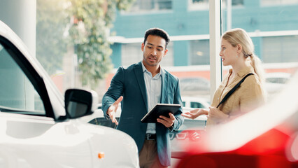 Tablet, customer and salesman with talking for car dealership, transport model and motor for rental service. Showroom, woman and male seller with tech for assistance, vehicle features and discussion © peopleimages.com